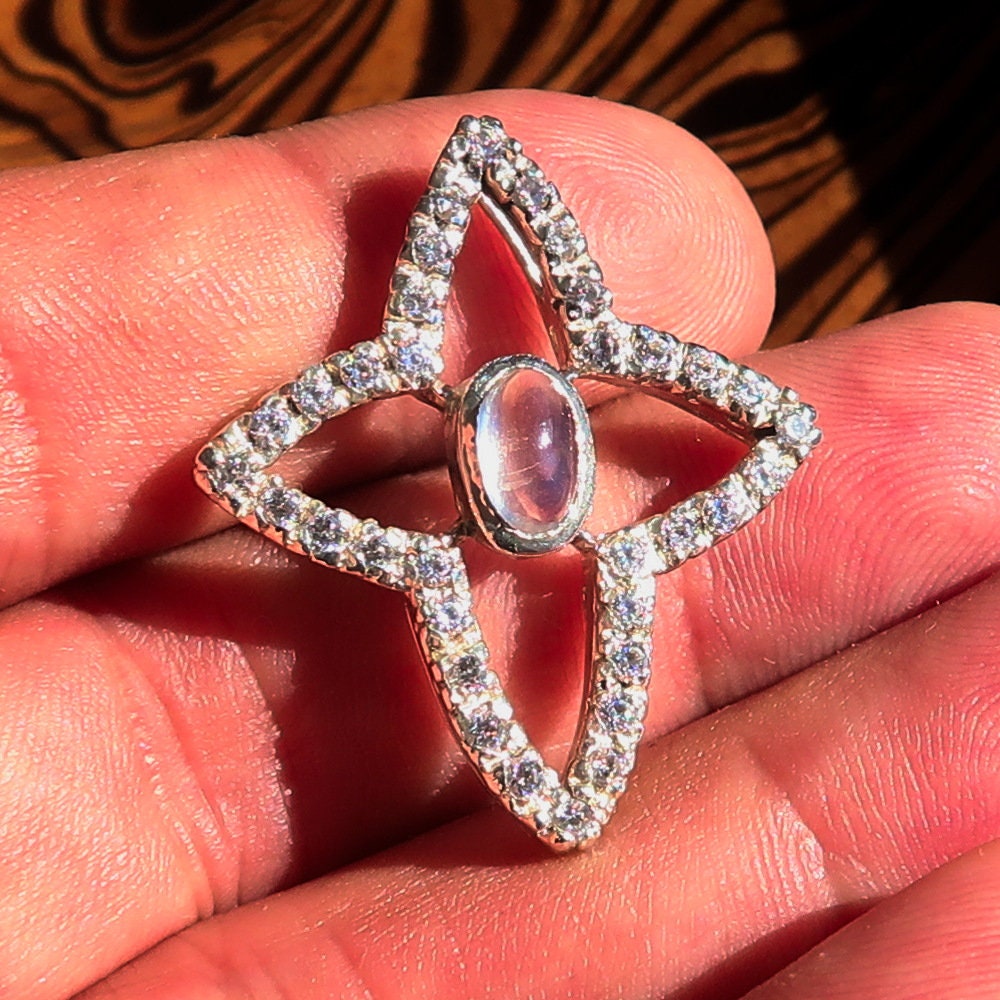 A beautiful sterling silver pendant necklace featuring a moonstone and cubic zirconias, showcasing its elegant design and craftsmanship.